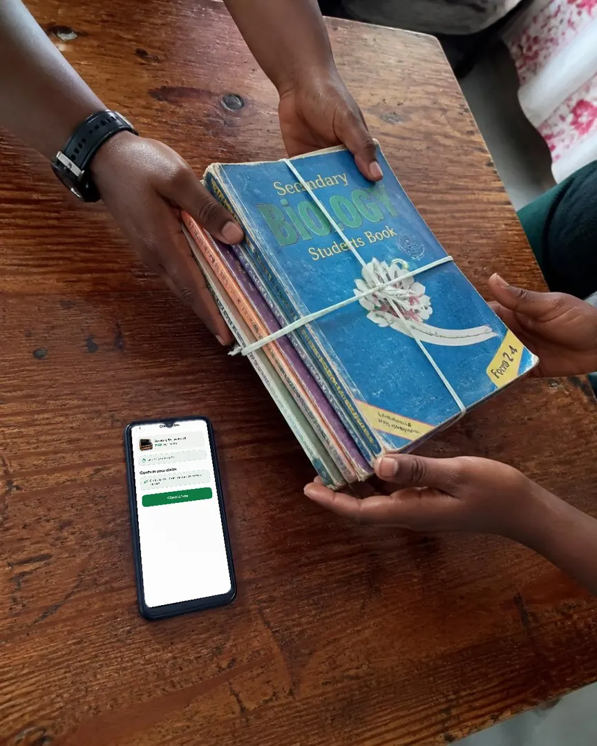 Revision books handed across a table, a phone with Chukua open beside them